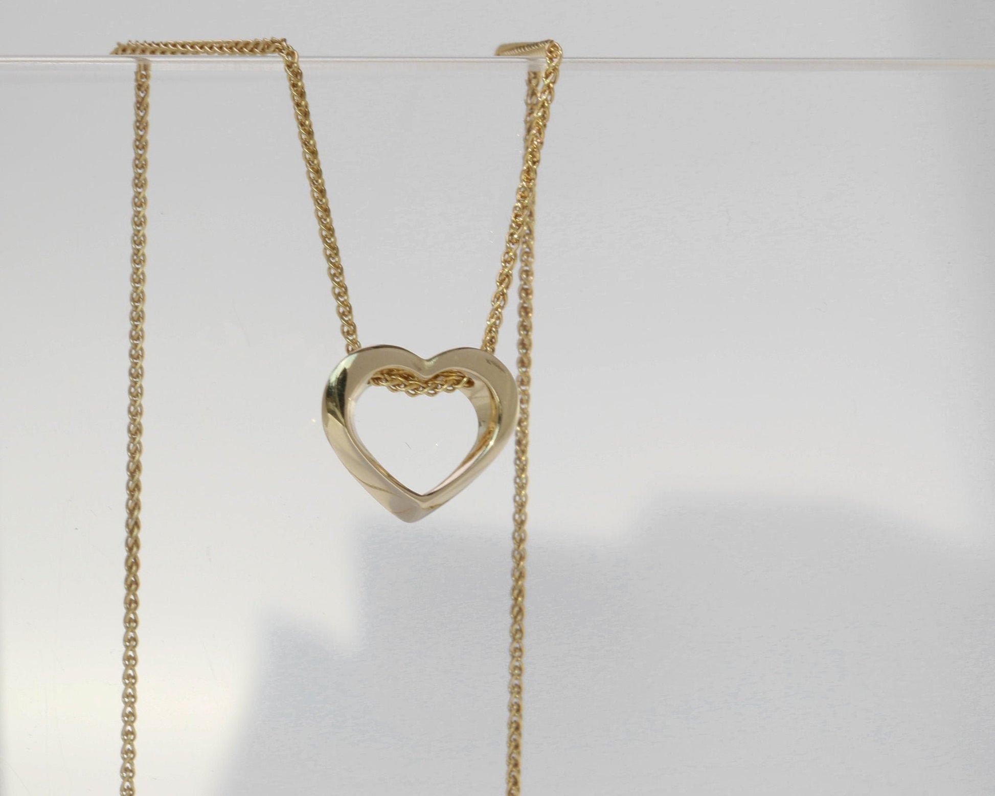 Gold heart-shaped necklace on a white background