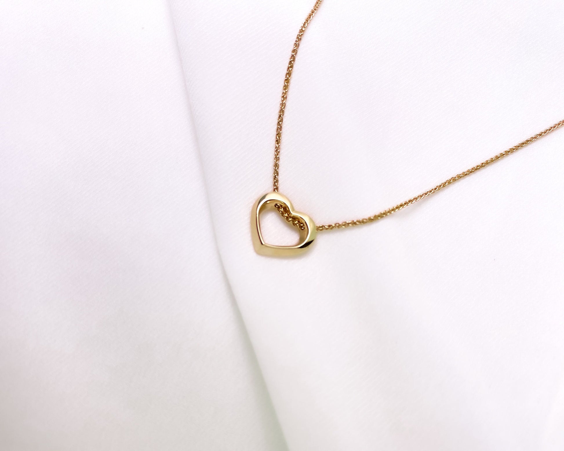 Gold heart-shaped necklace on a white background