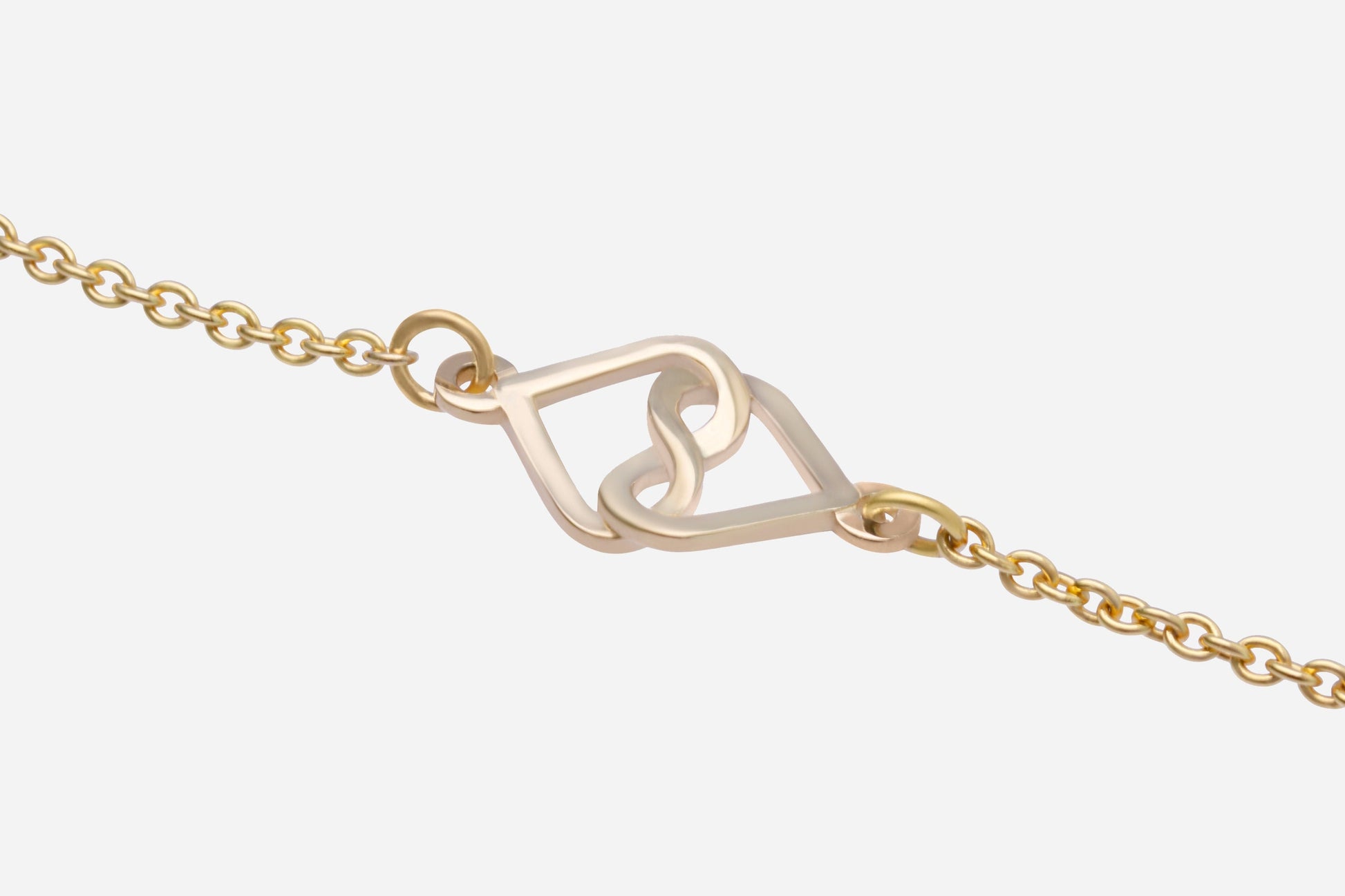 Gold bracelet with a heart-shaped clasp on a white background