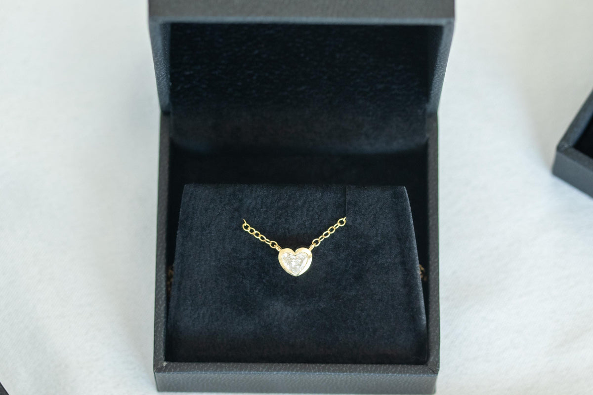 Heart shape diamond bezel necklace in 14K yellow gold, presented in a black jewelry box