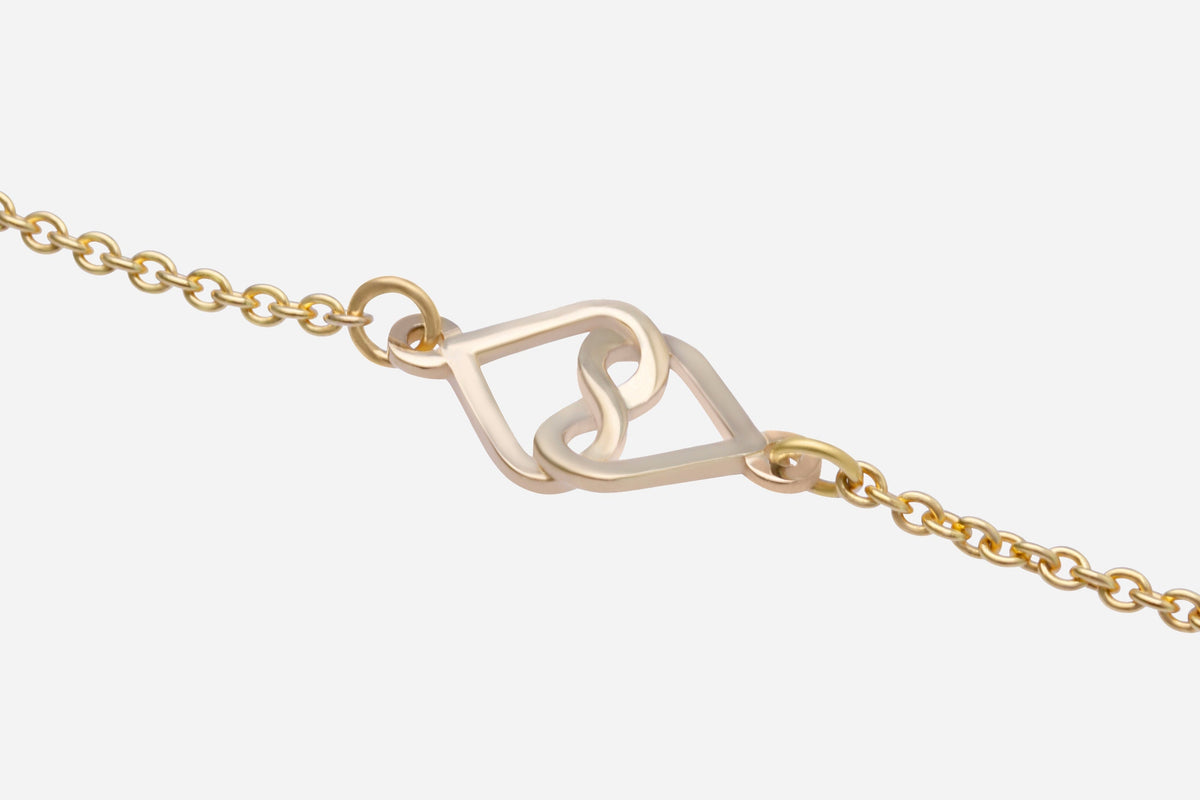 14K yellow gold infinity heart charm bracelet on a white background