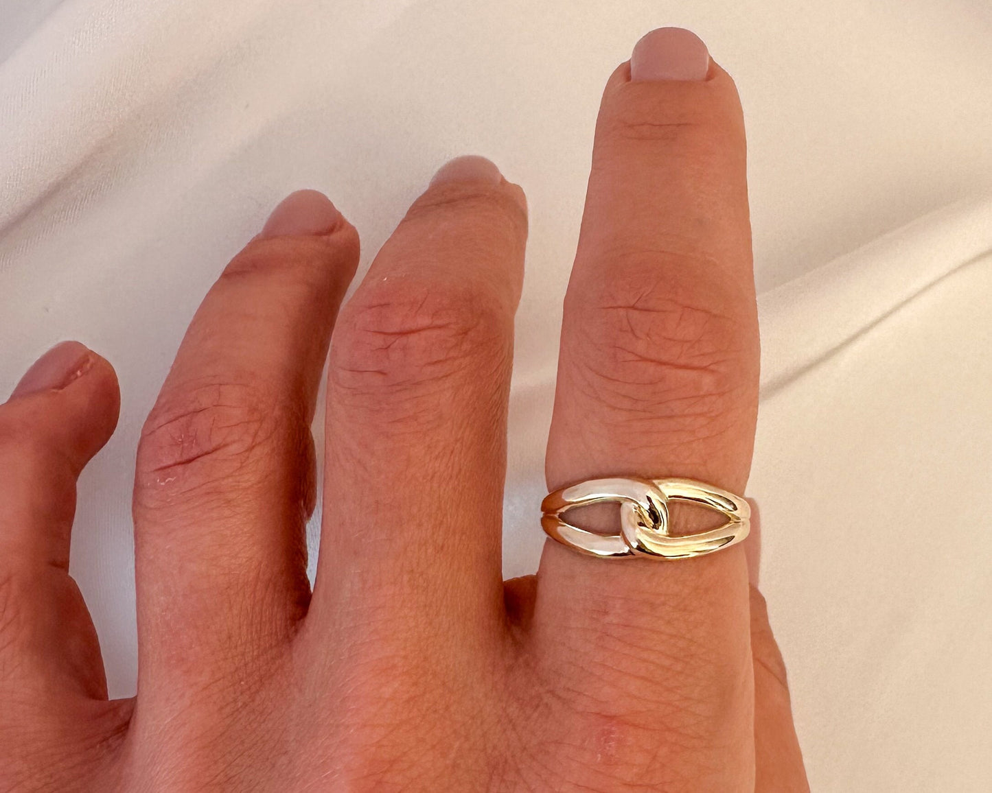 Gold infinity love knot ring worn on the finger
