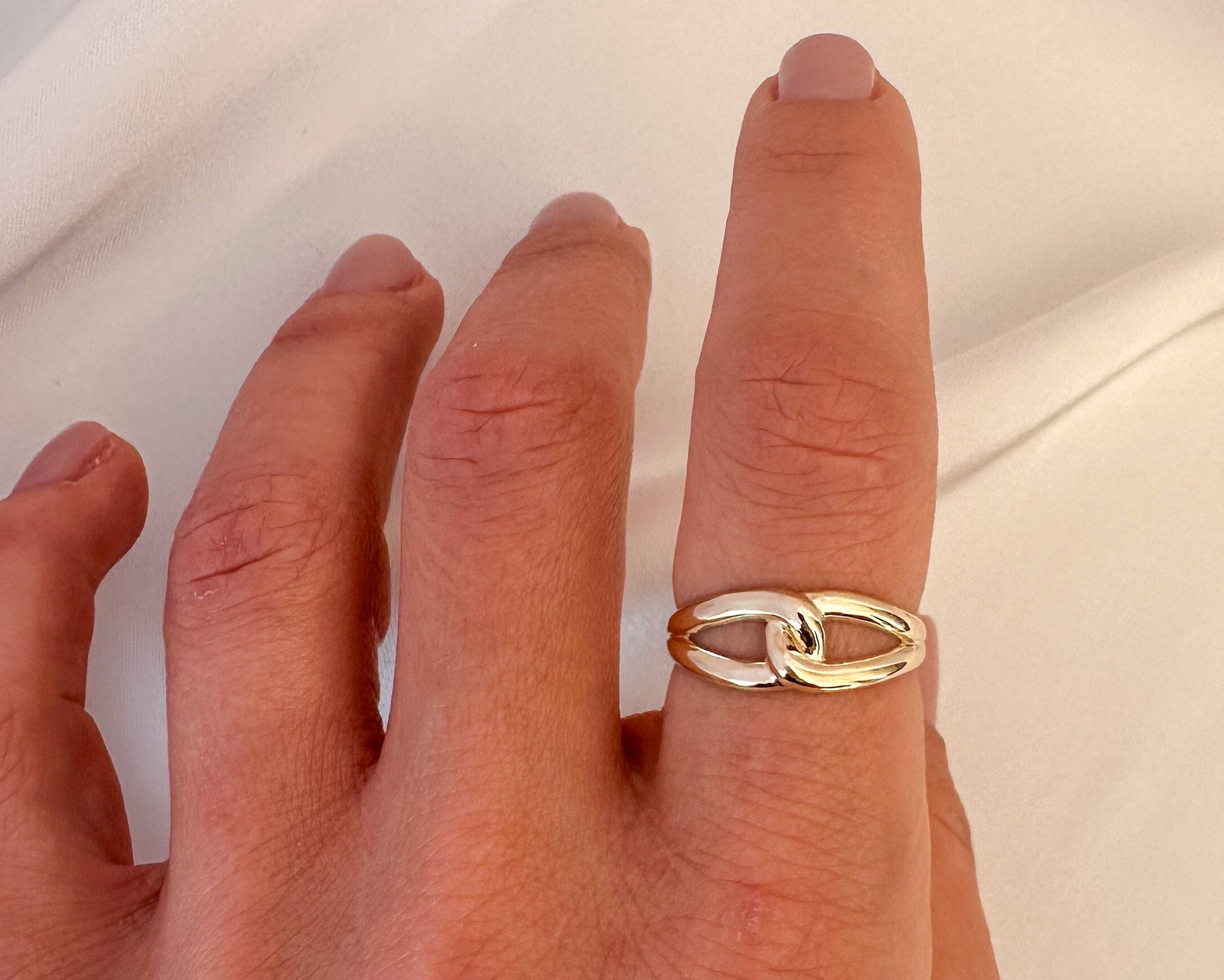 Gold infinity love knot ring worn on the finger