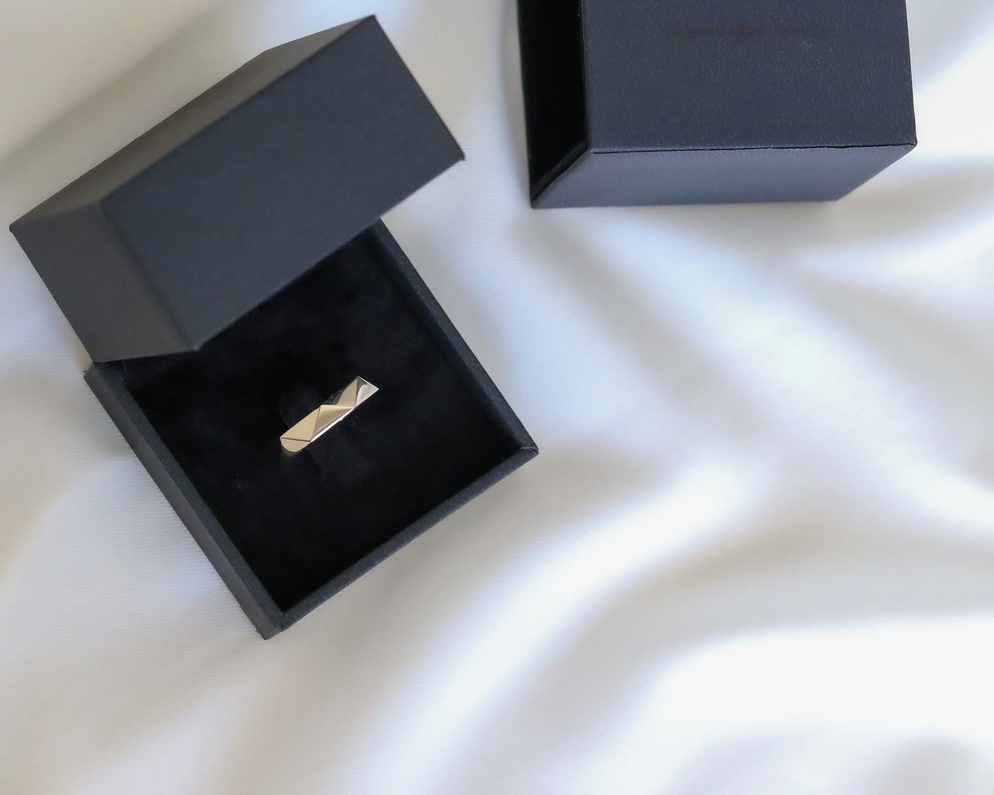 open and closed jewelry boxes gold ring white fabric