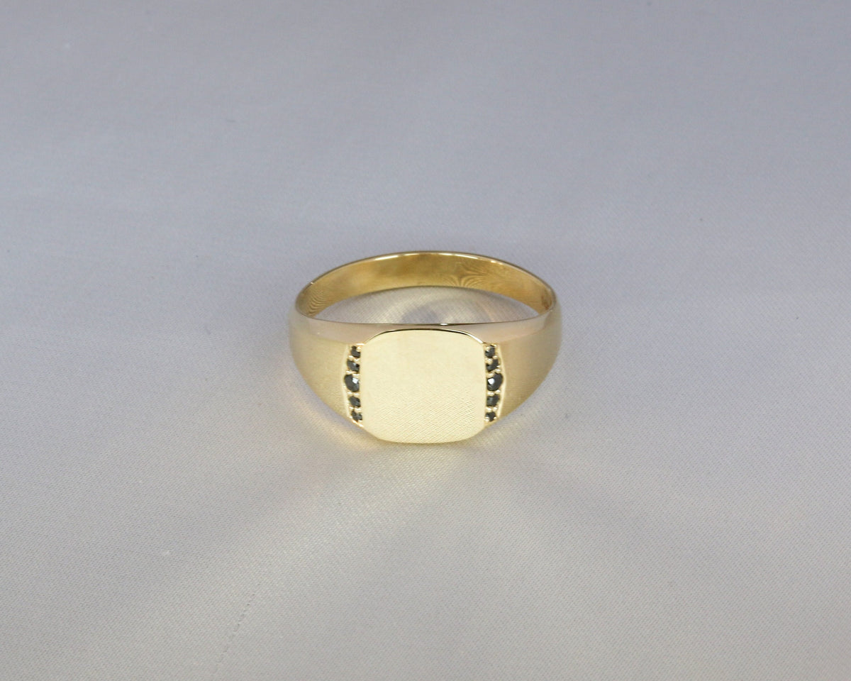 Men's yellow gold signet ring with flush-set black diamonds, front view
