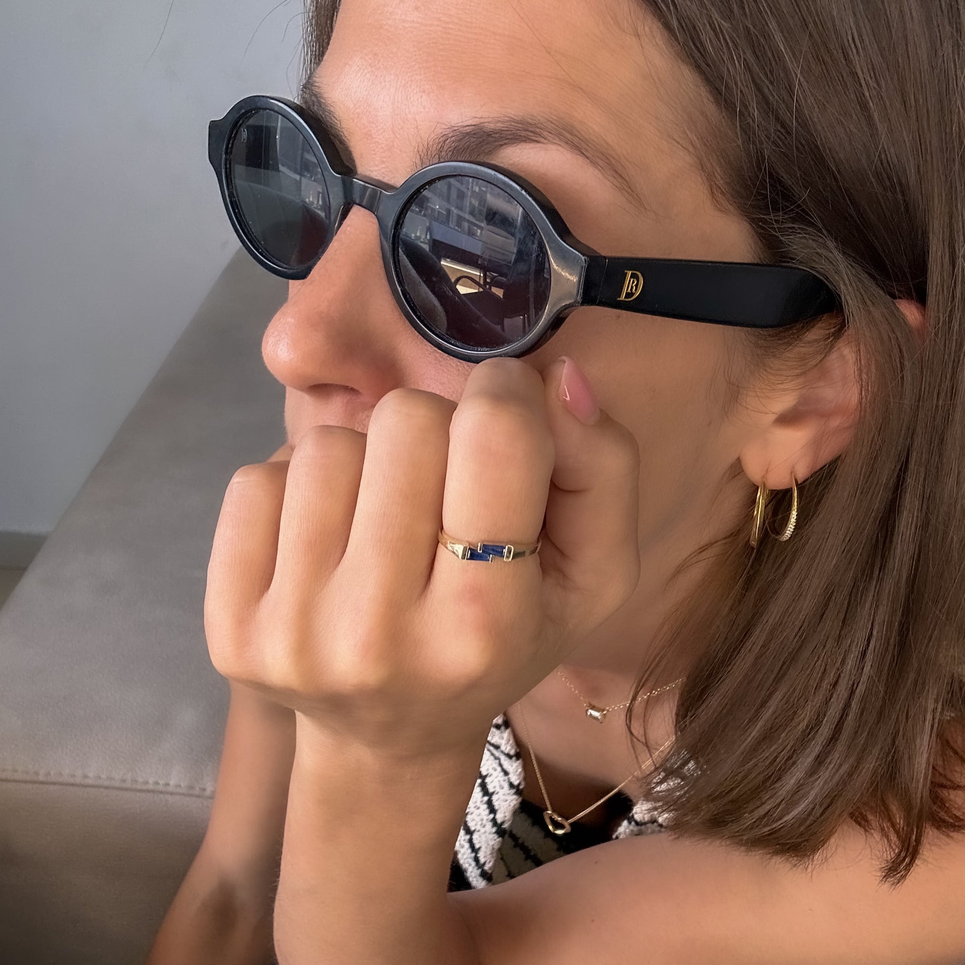 A gold ring with two blue sapphires set cheek to cheek on women's finger.