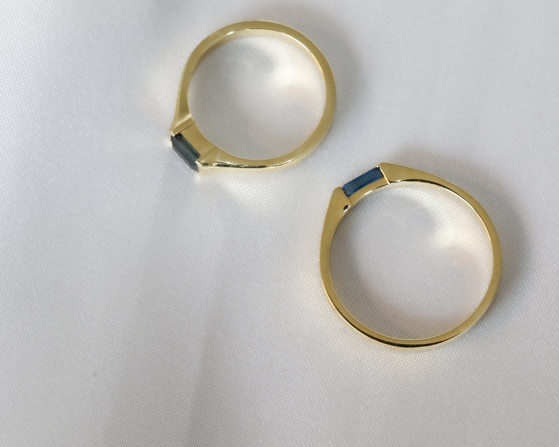 Gold hoop earrings with blue stones on a white background
