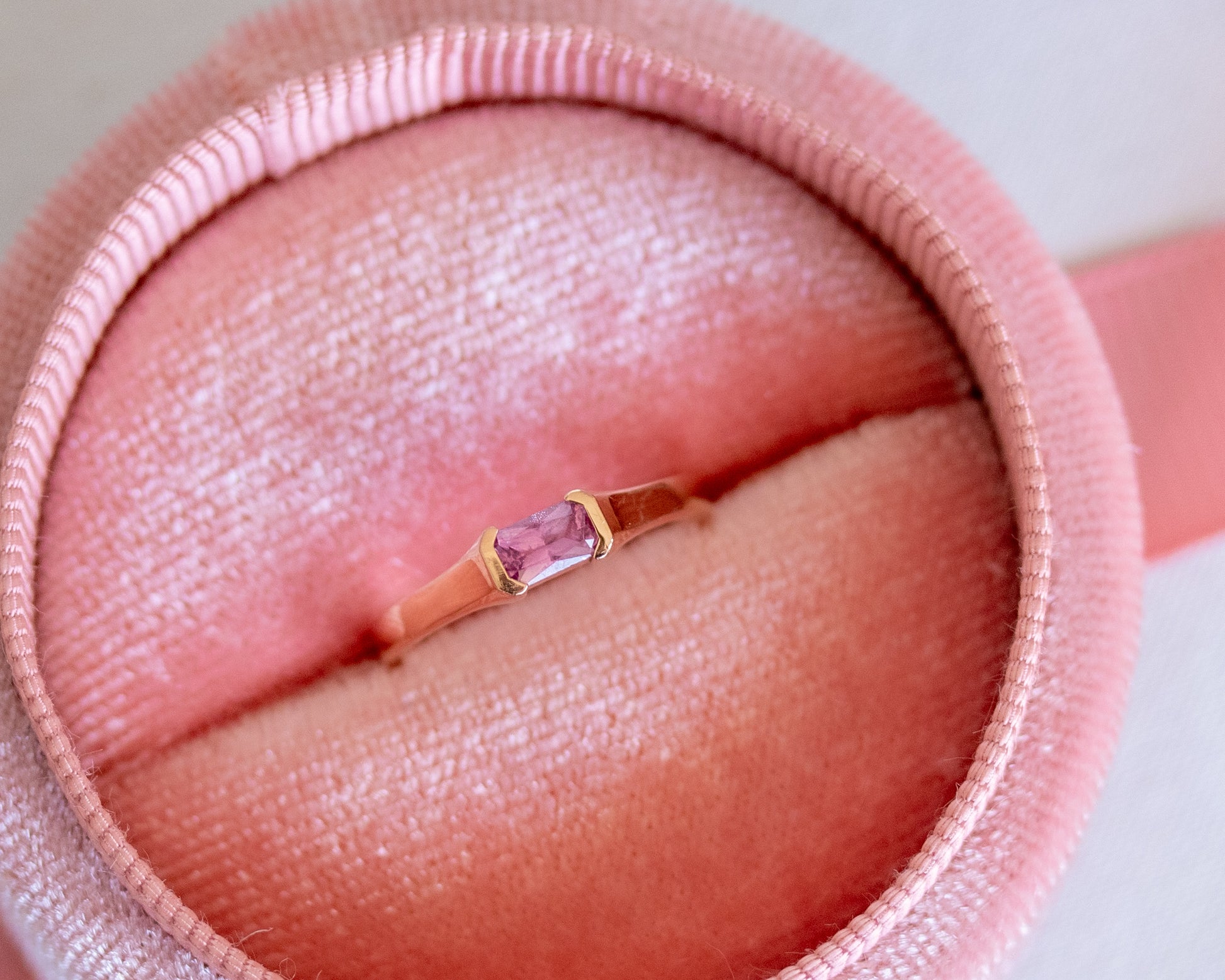 Rose gold ring with a pink sapphire in a pink jewelry box