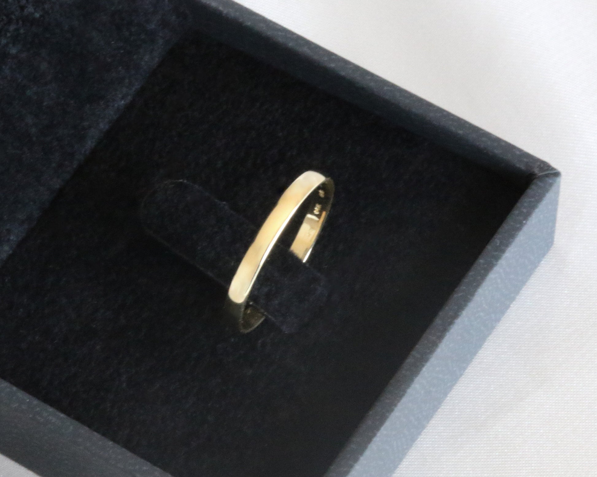 Gold ring in a black box on a white background