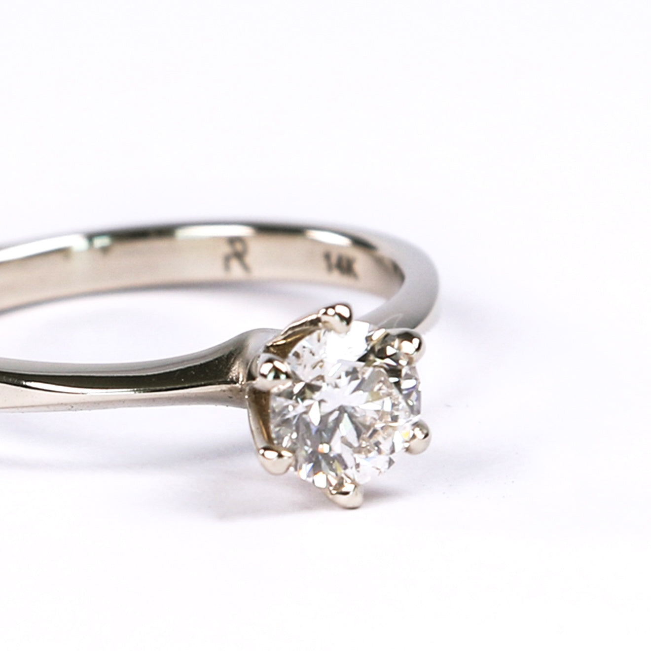 close up on diamond setting of classic solitaire engagement ring in white gold