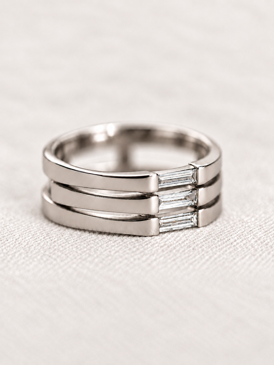 Angled view of a 14K white gold ring with three needle baguette diamonds and open space between them