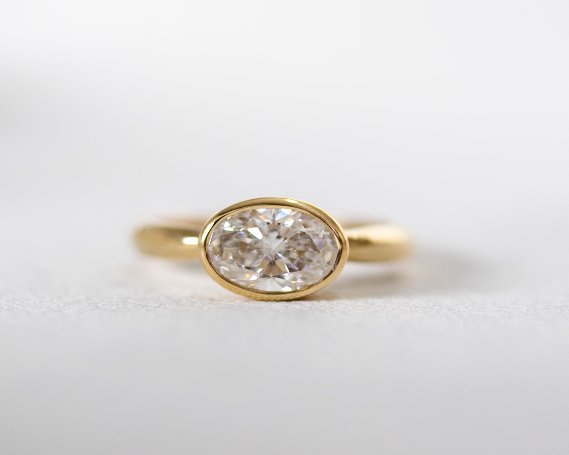 Oval diamond solitaire engagement ring in solid 14K yellow gold, bezel-set design by Rotem Avitan Jewelry — fine handmade gold ring.