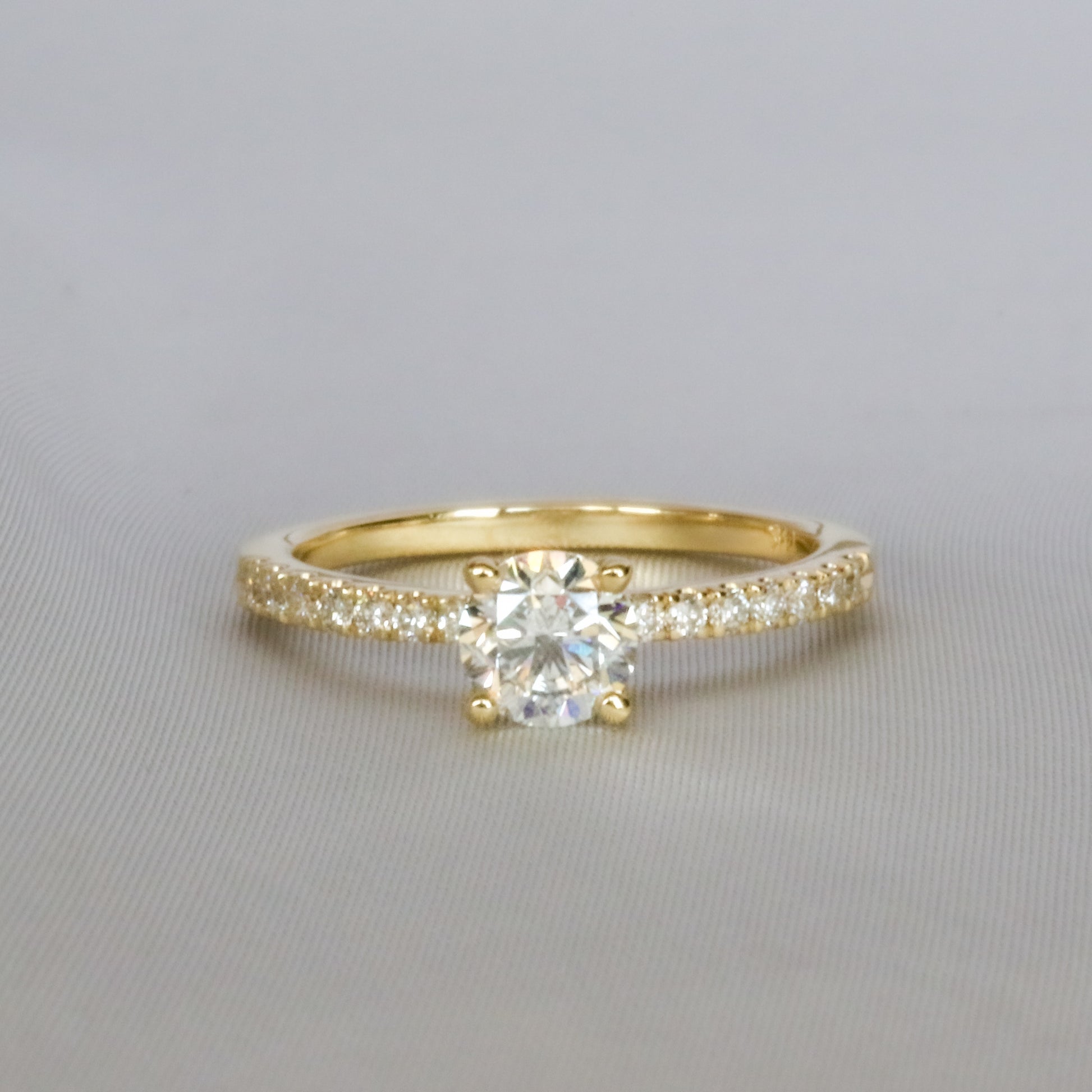 front view of diamond ring in 14K gold embellished diamonds in pave setting on gray background
