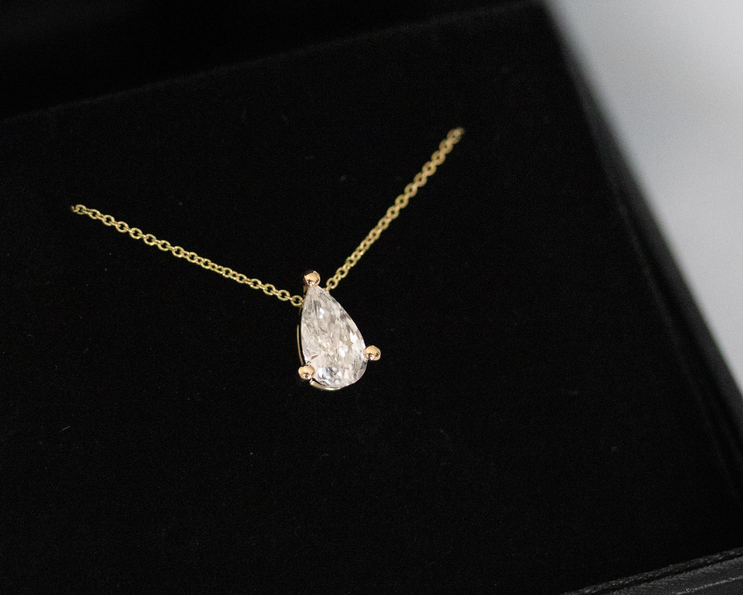 pear diamond necklace displayed on black velvet box 14K gold