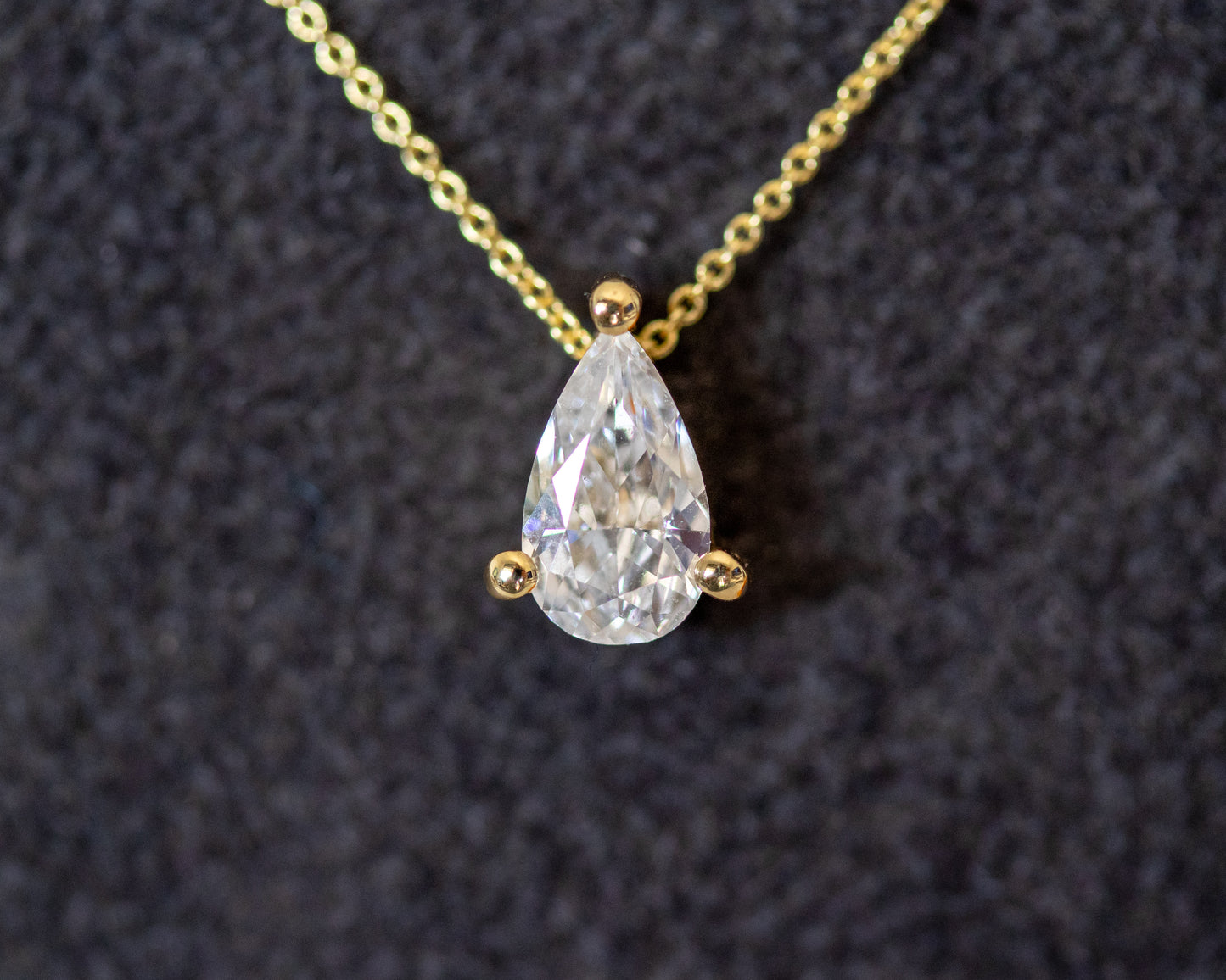 pear cut diamond solitaire pendant 14K yellow gold chain close-up