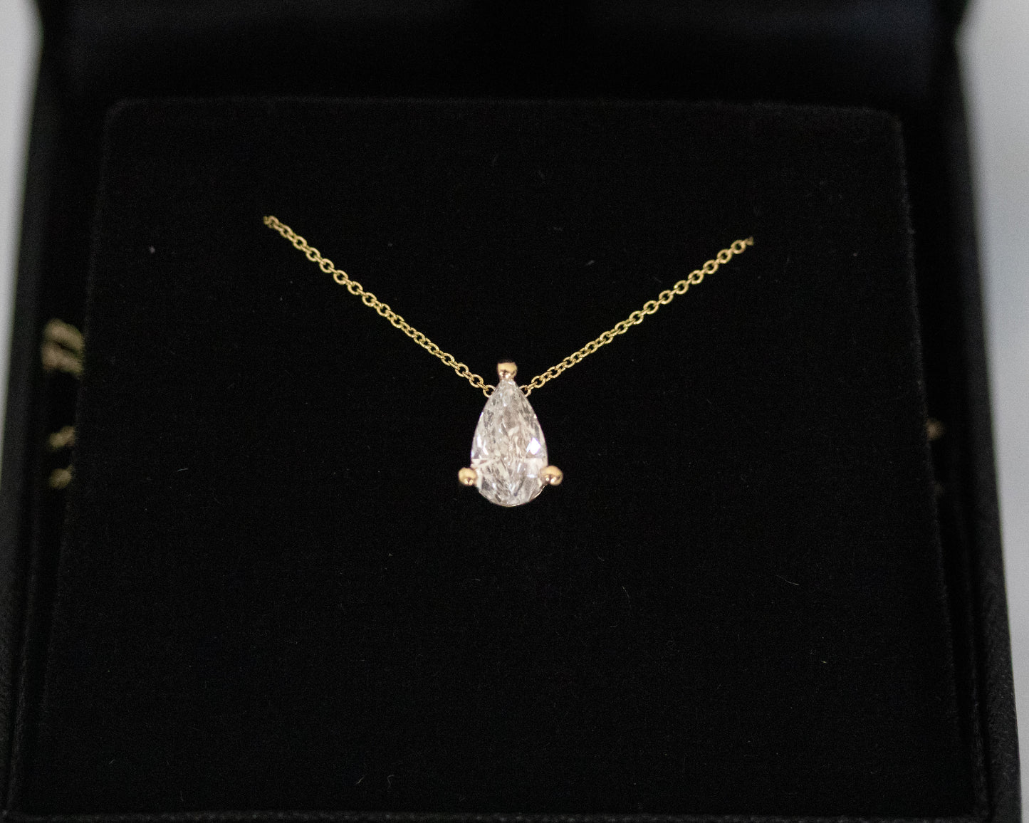 pear cut diamond solitaire pendant 14K yellow gold black background
