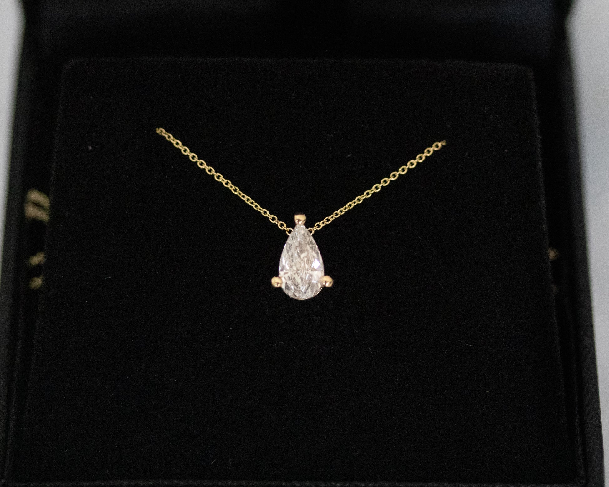 pear cut diamond solitaire pendant 14K yellow gold black background