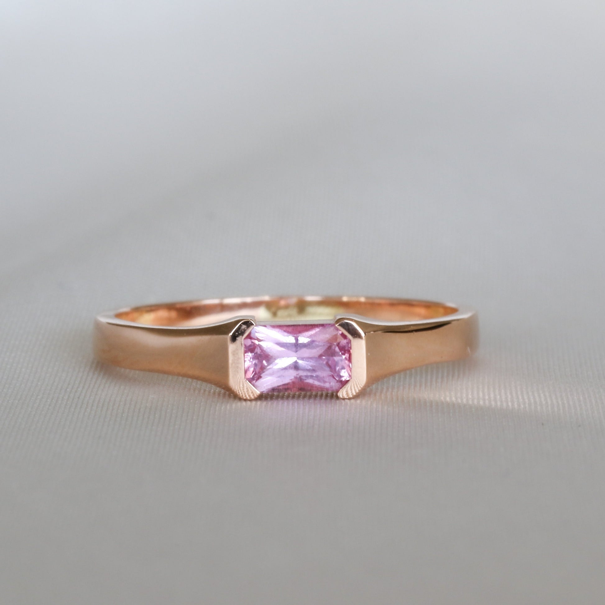 A natural pink sapphire ring set in a 14K rose gold band with a minimalistic solitaire design.