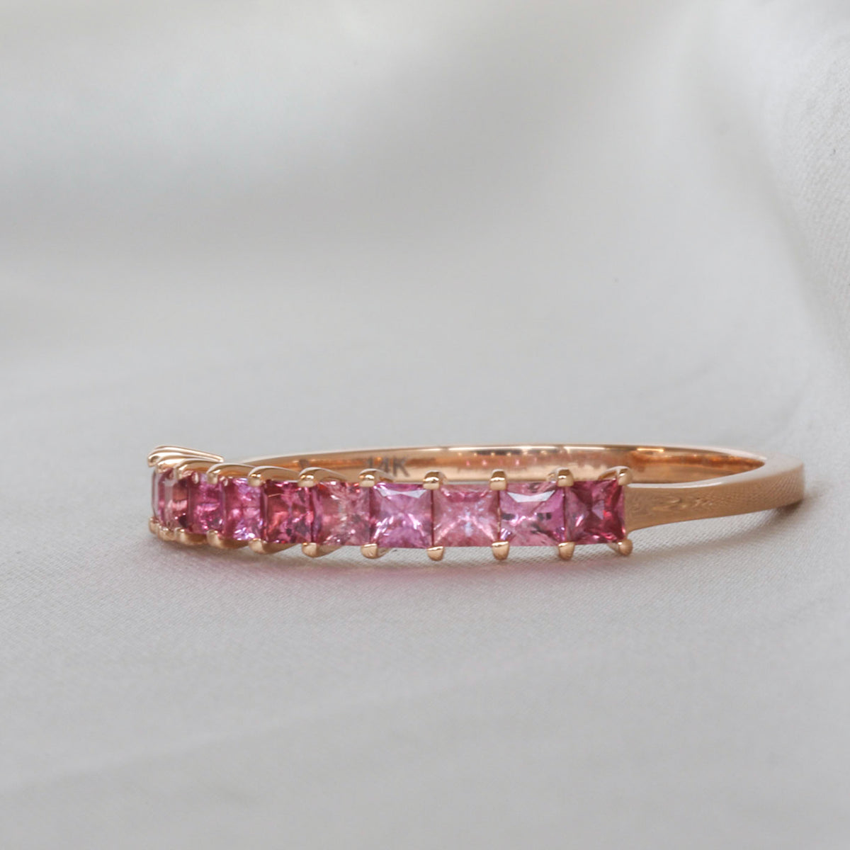 Pink sapphire half eternity band with 11 princess cut stones in 14K rose gold