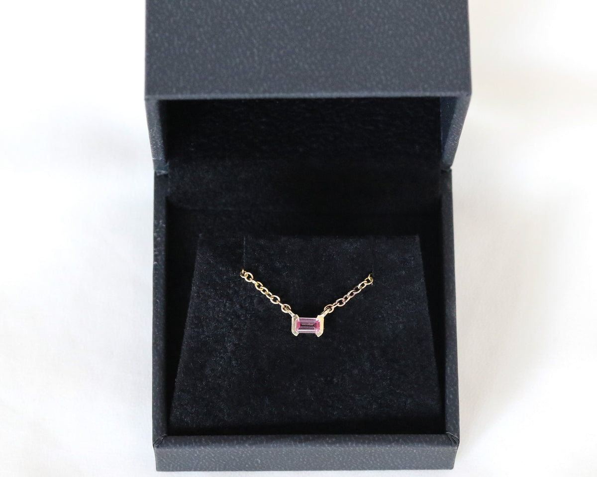 Pink sapphire necklace in yellow gold presented in an open black jewelry box