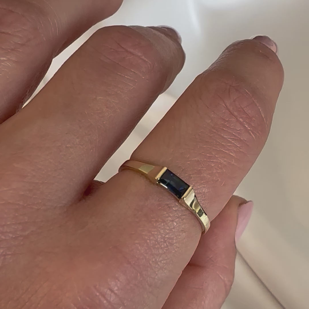 hand showing sapphire baguette ring on finger
