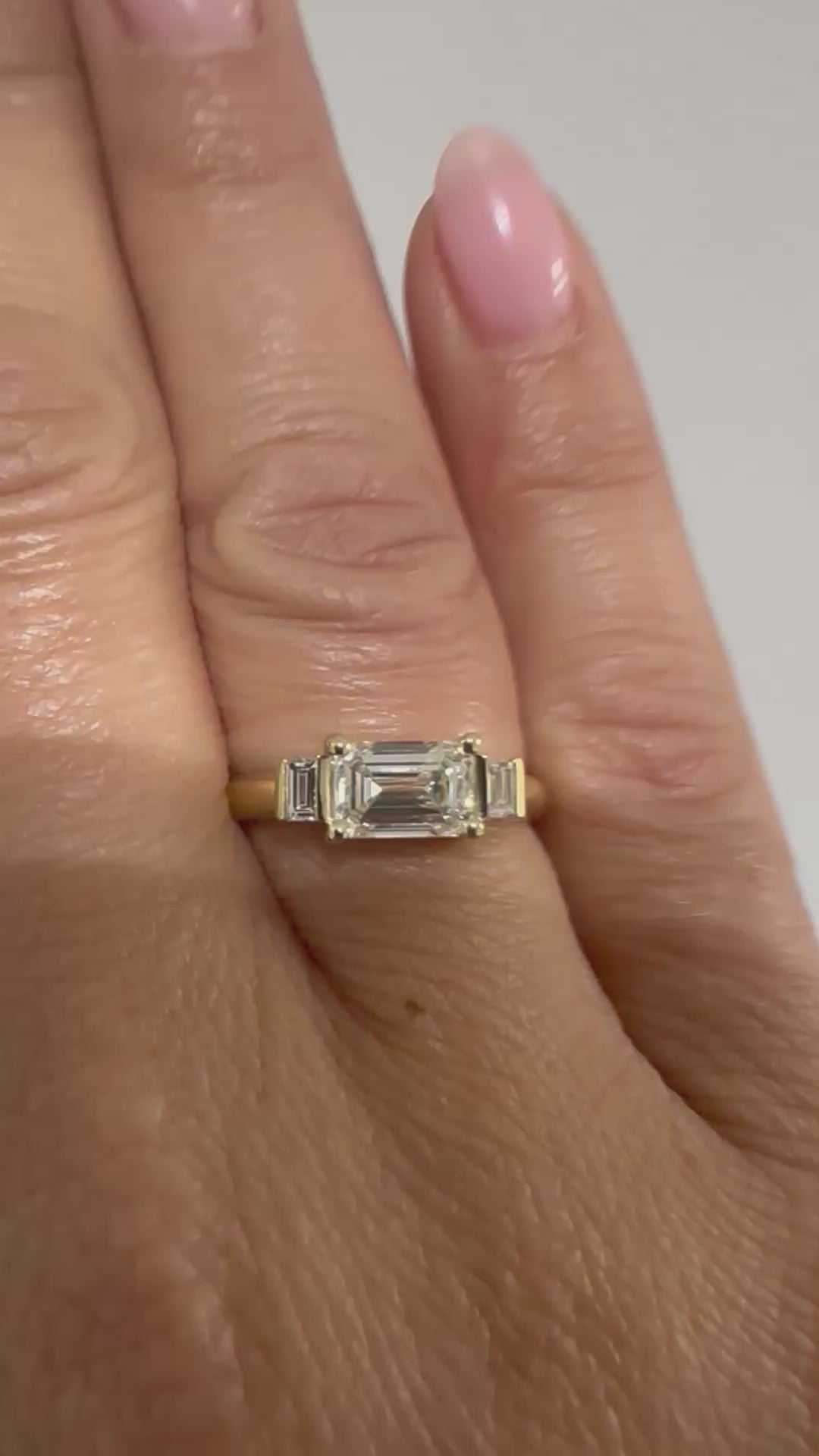 Emerald cut diamond trilogy ring worn on hand, video