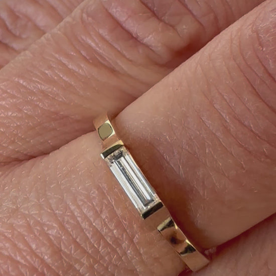 East-west baguette diamond gold ring worn on the hand