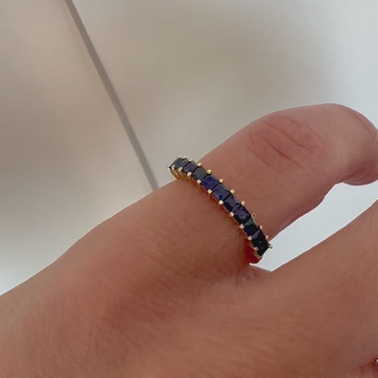  princess cut blue sapphire eternity ring displayed on women's pinky finger
