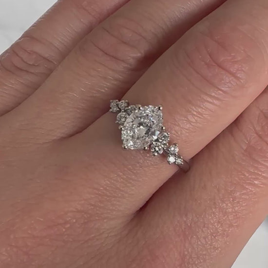 Video of an oval diamond engagement ring worn on a hand, showing the diamond's sparkle as it moves.