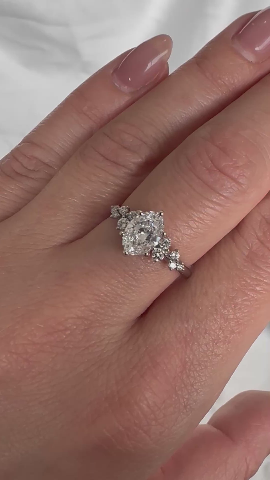 Video of an oval diamond engagement ring worn on a hand, showing the diamond's sparkle as it moves.