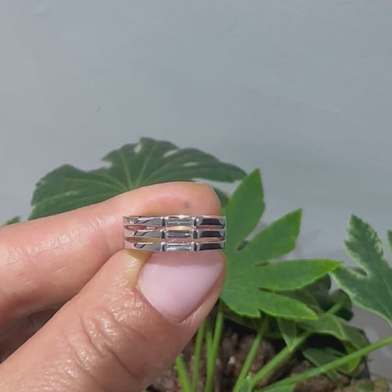 A minimalist ring design with a stack of needle baguette cut sapphires, set in a 14K gold band, displayed in women's hand