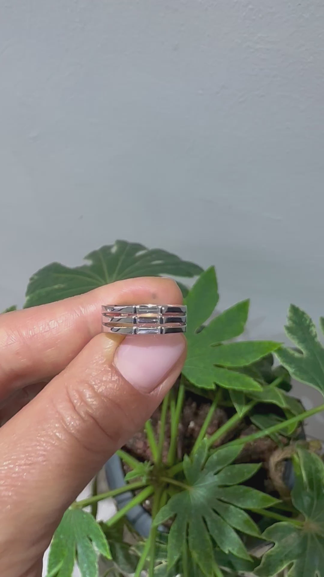 A minimalist ring design with a stack of needle baguette cut sapphires, set in a 14K gold band, displayed in women's hand