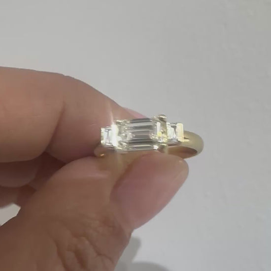 Emerald cut diamond trilogy ring on hand, video