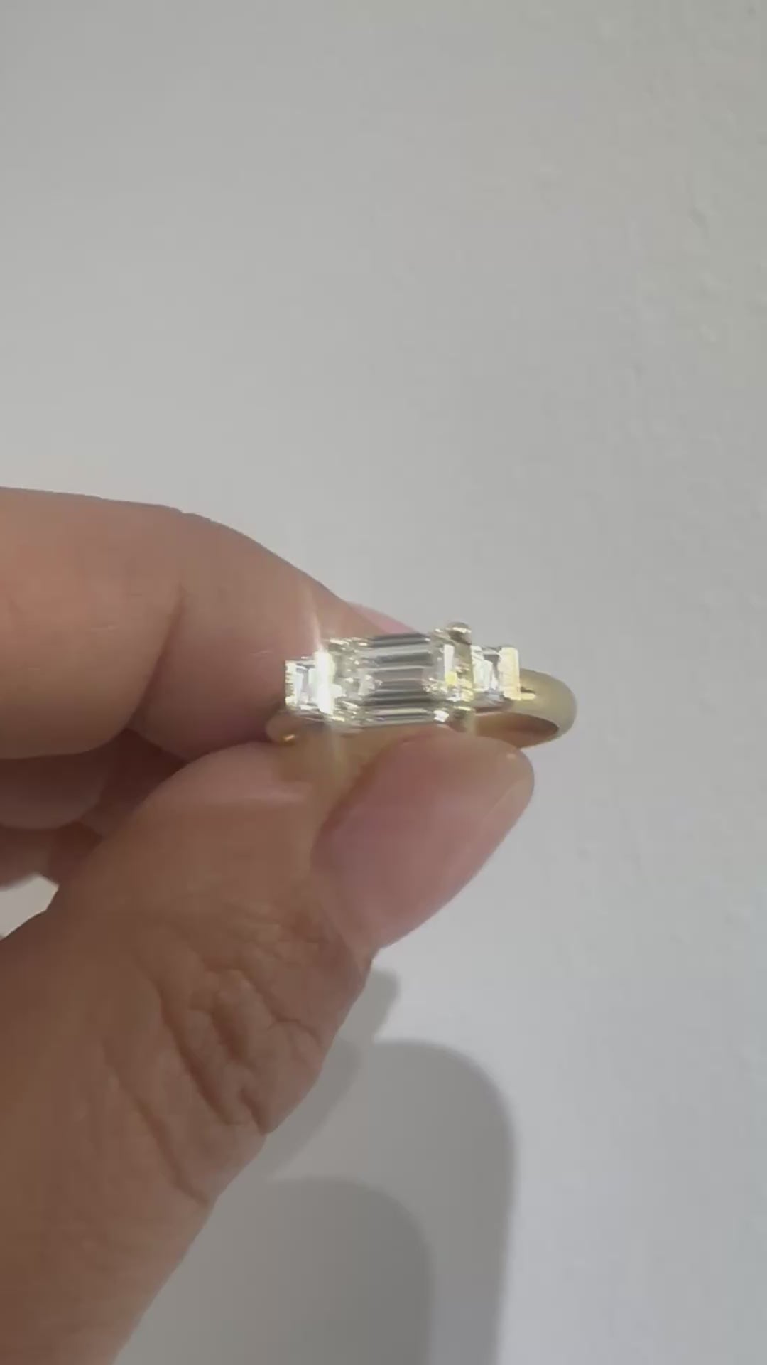 Emerald cut diamond trilogy ring on hand, video