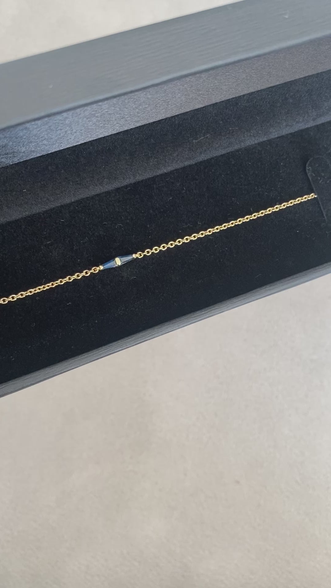 14K gold bracelet with a geometric blue sapphire detail presented inside a jewelry box