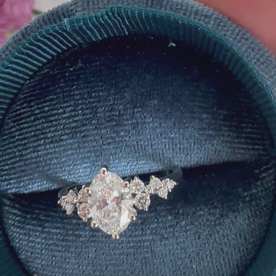 Video of an oval diamond engagement ring turning inside a round velvet ring box to show the sparkle.