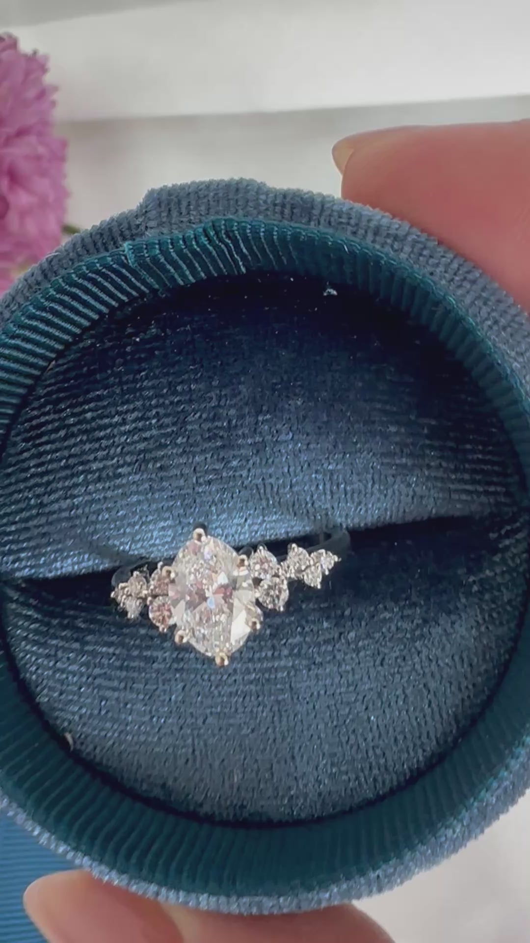 Video of an oval diamond engagement ring turning inside a round velvet ring box to show the sparkle.