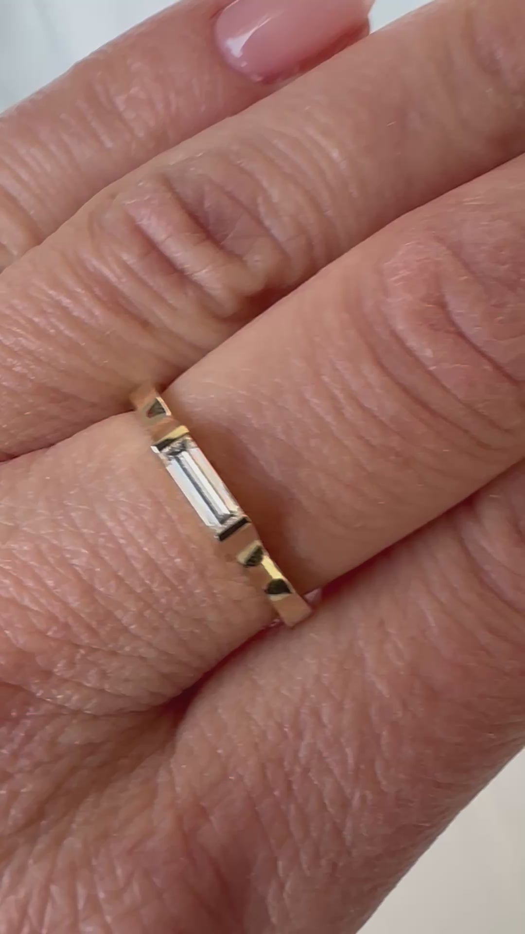 East-west baguette diamond ring shown on the hand