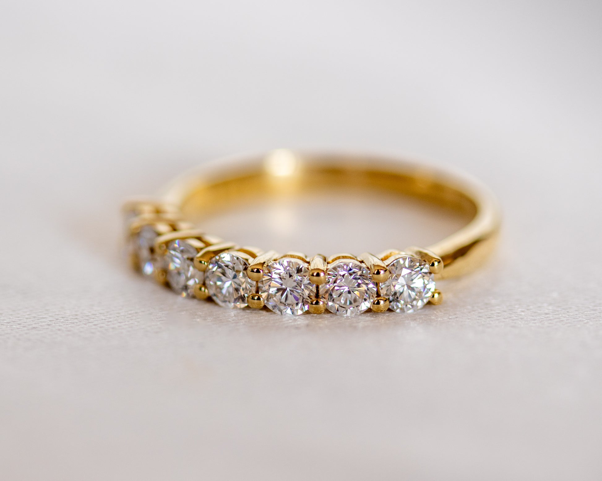 Round diamond half eternity band in gold, side view