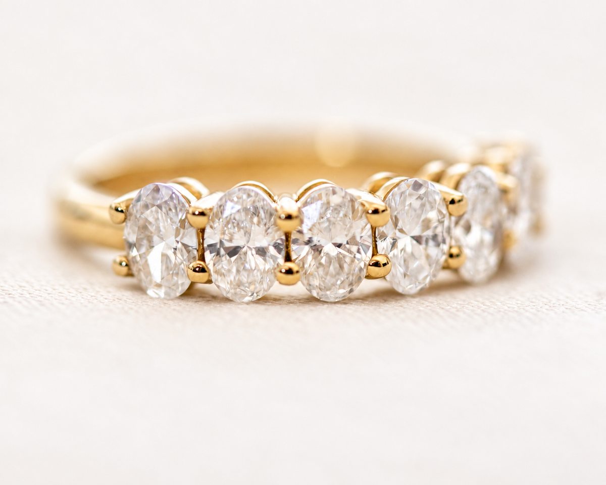 Seven-stone oval-cut diamond ring in gold, close-up side view
