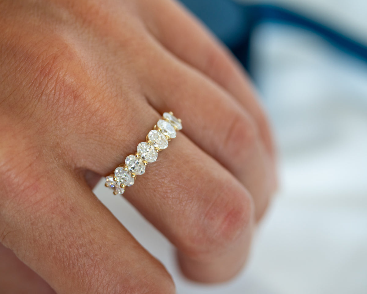 Seven-stone oval-cut diamond ring worn on hand