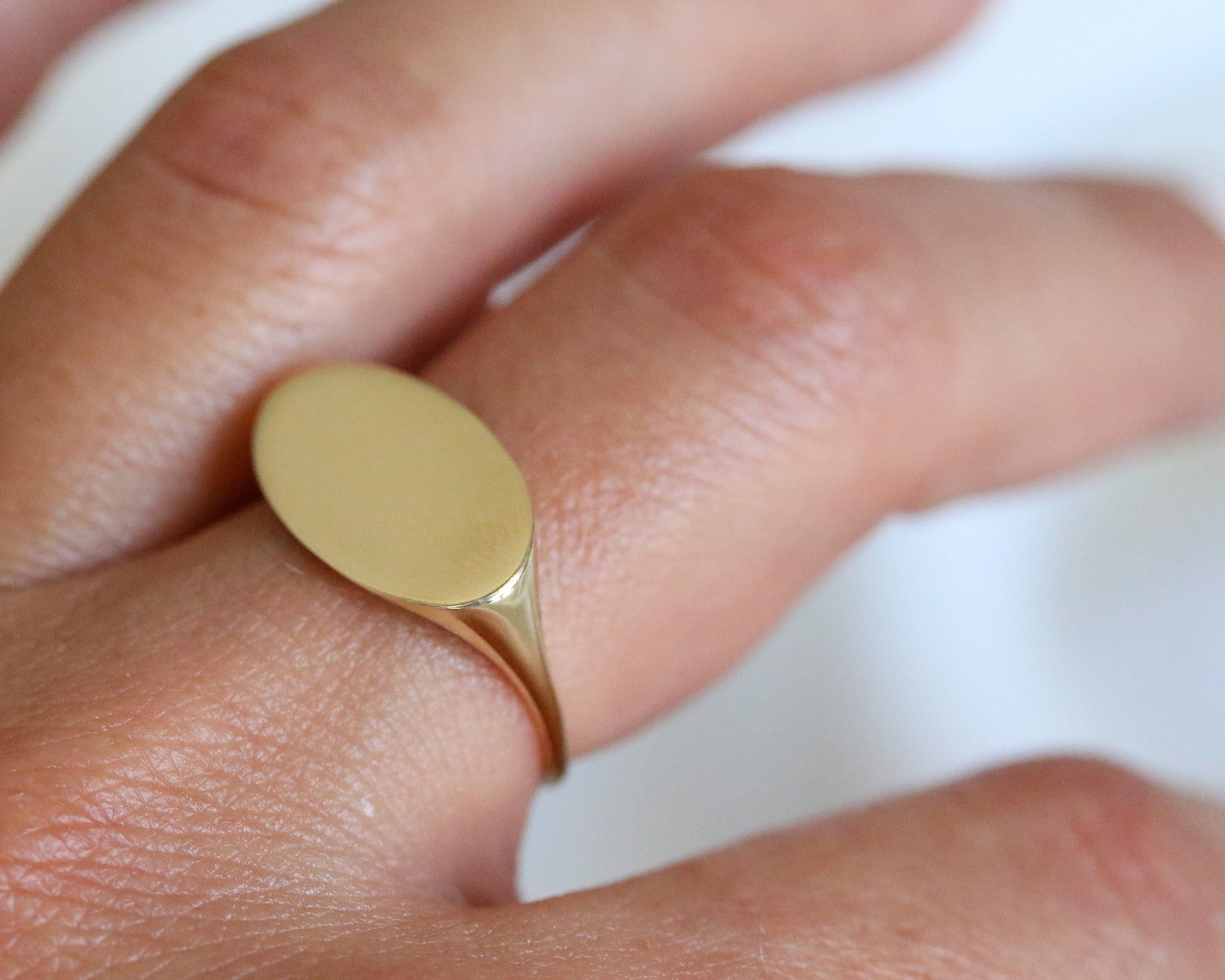 Gold ring on a finger with a blurred background