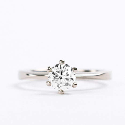 Six-prong round diamond solitaire engagement ring on a flat white gold band, front view
