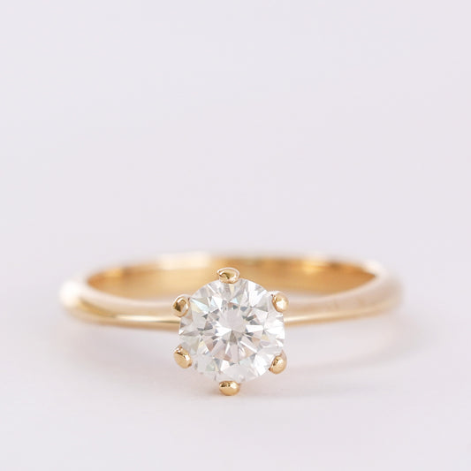 yellow gold six prong diamond ring on white gray background