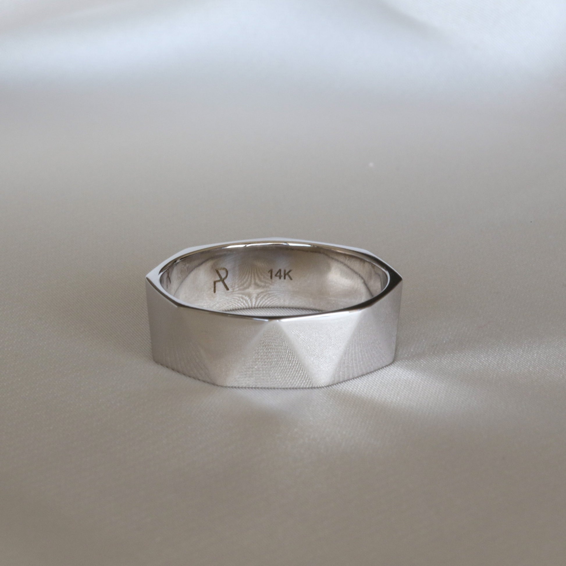 A 14K yellow gold faceted triangle ring on a white background.
