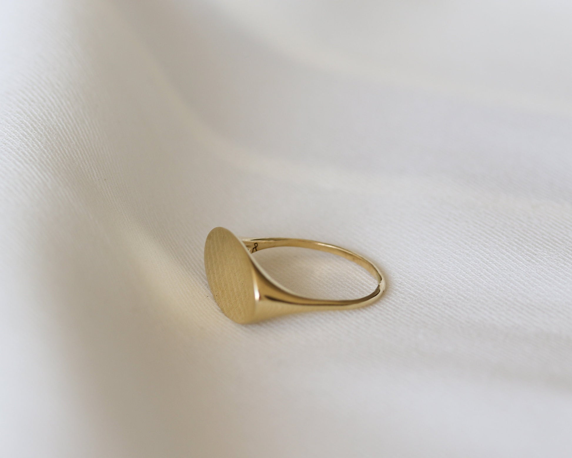 Gold ring on a light beige fabric background