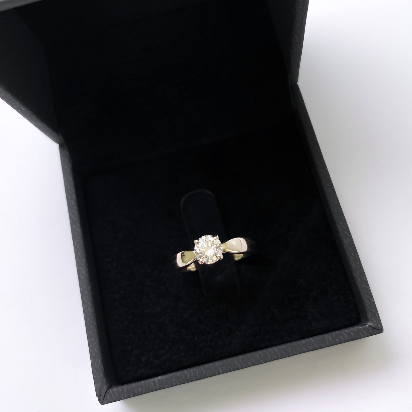 A 14K natural diamond solitaire engagement ring displayed in a black box with a velvet interior.