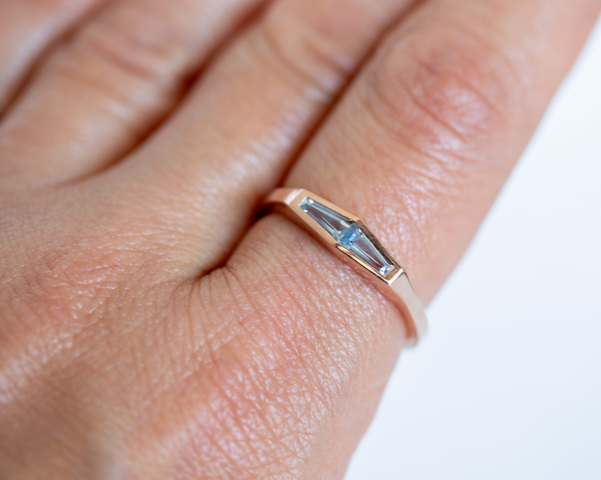 Tapered baguette aquamarine ring in 14K rose gold worn on the hand