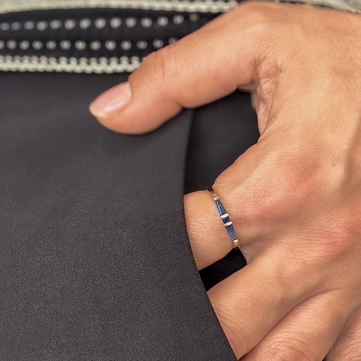 Side view of a tapered baguette blue sapphire ring in yellow gold on the finger