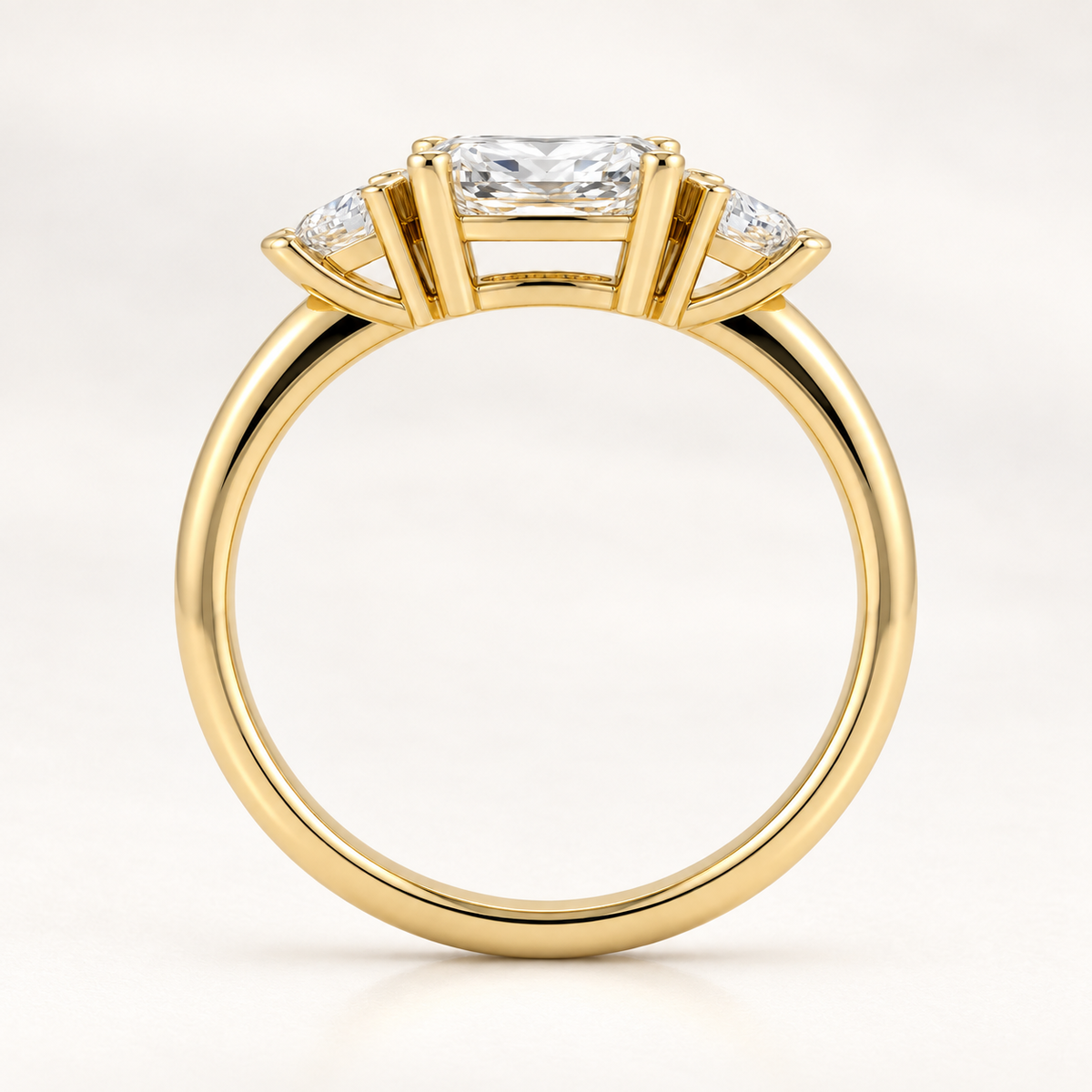 Top-down view of a radiant-cut diamond ring with trillion-cut side stones in yellow gold